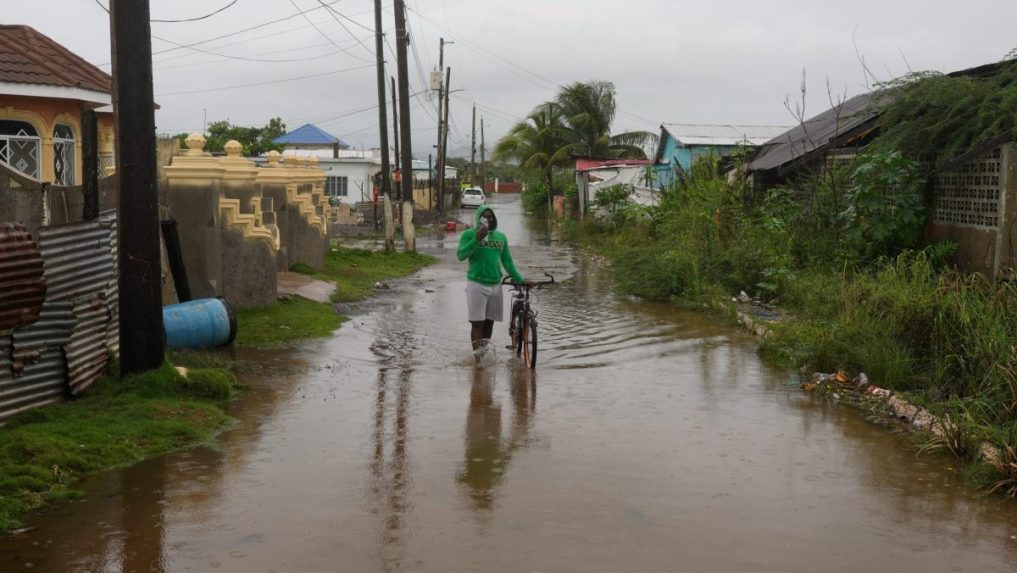 MuÃ
¾ sa brodàzaplavenou ulicou pred prÃÂchodom hurikánu Melissa v Old Harbour.