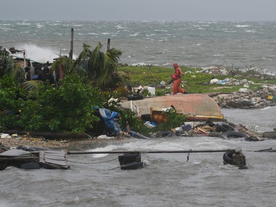 Muž kráča pozdĺž pobrežia v Kingstone na Jamajke.