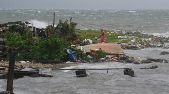 Muž kráča pozdĺž pobrežia v Kingstone na Jamajke.