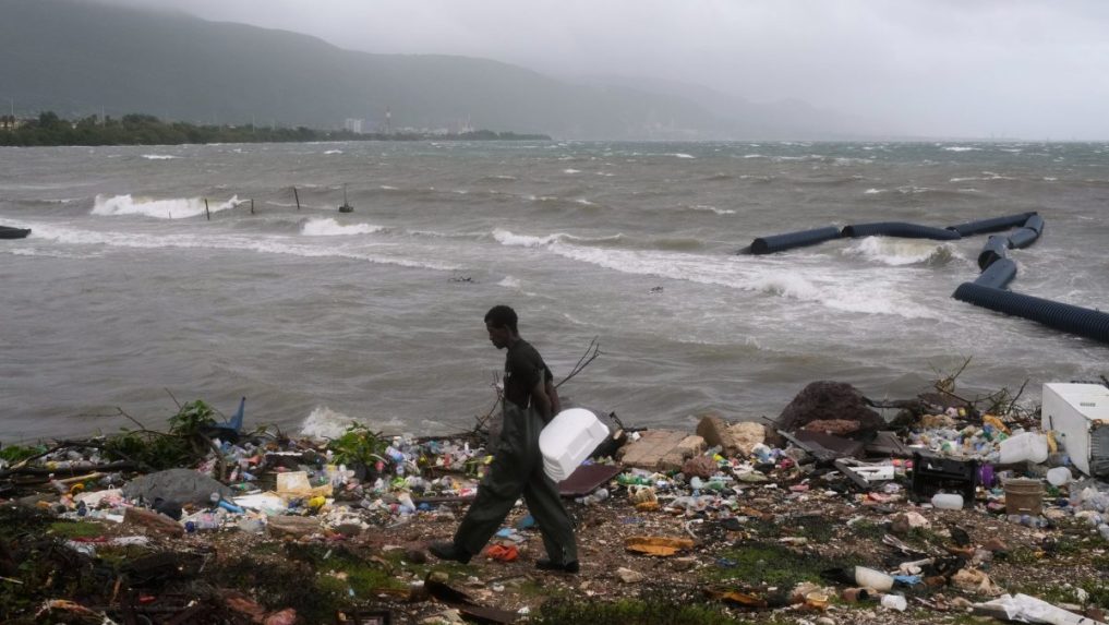 Muž kráča pozdĺž pobrežia počas hurikánu Melissa v Kingstone na Jamajke.