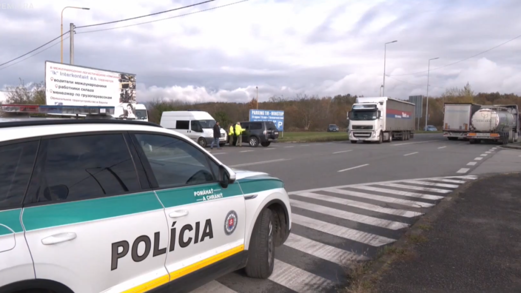 policajné auto počas kontroly kamiónov