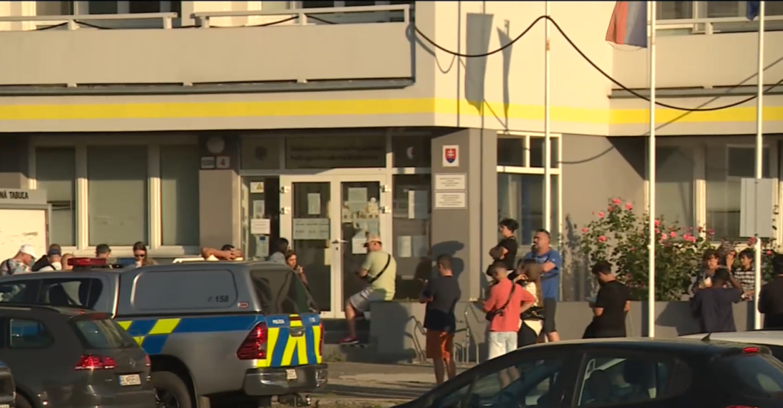 Na archívnej snímke rad ľudí pred cudzineckou políciou.