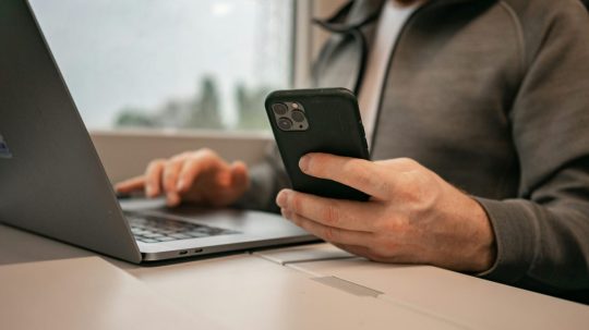 Ilustračná snímka muža píšuceho na telefóne.