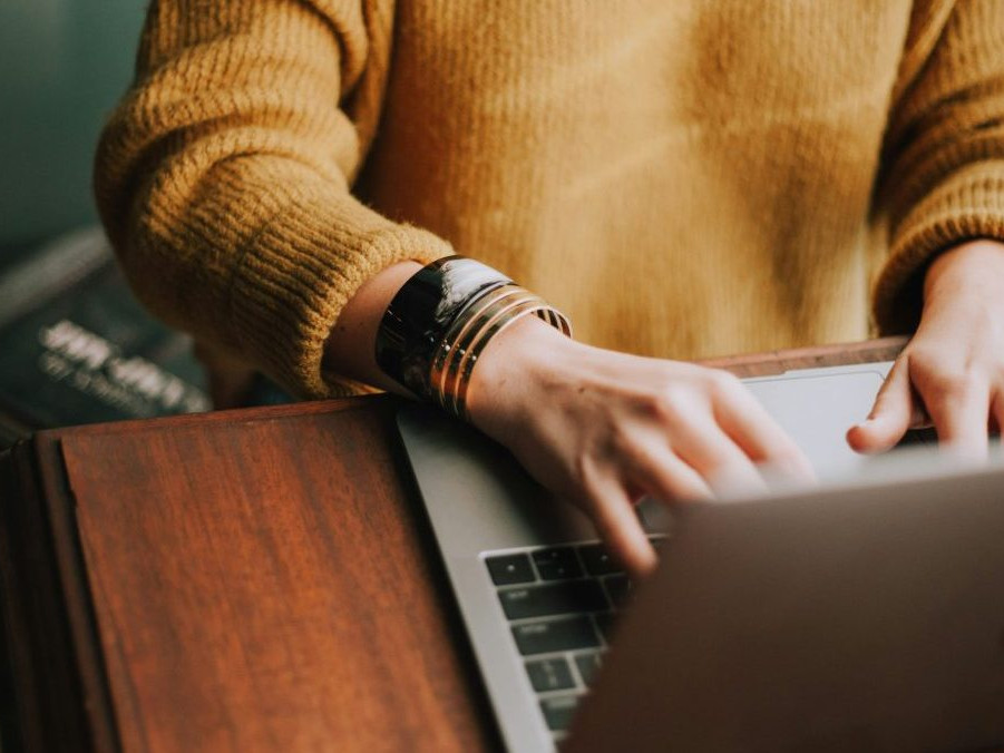 Na snímke žena píše na notebooku.