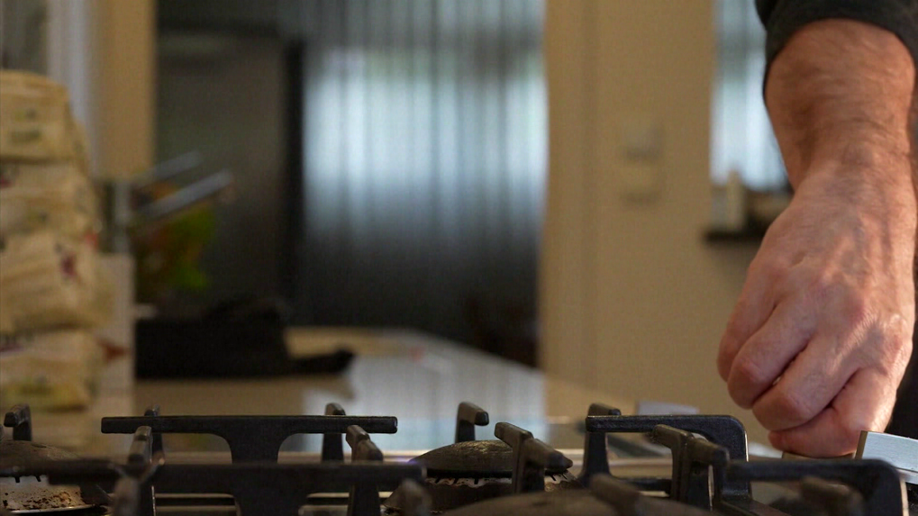 Na snímke osoba zapína horák na plynovom sporáku.