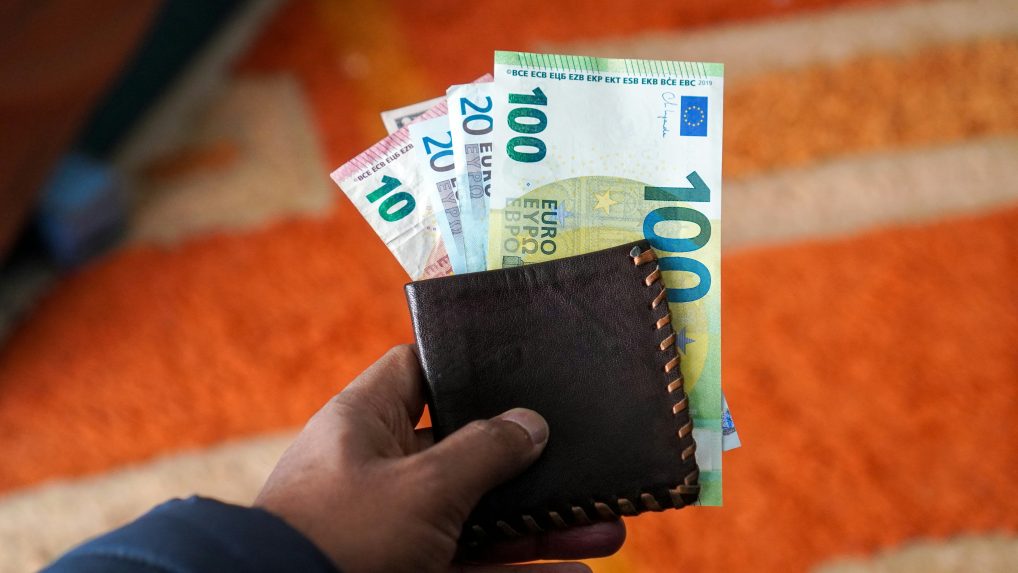 Na snímke osoba s peňaženkou, z ktorej trčia eurobankovky.