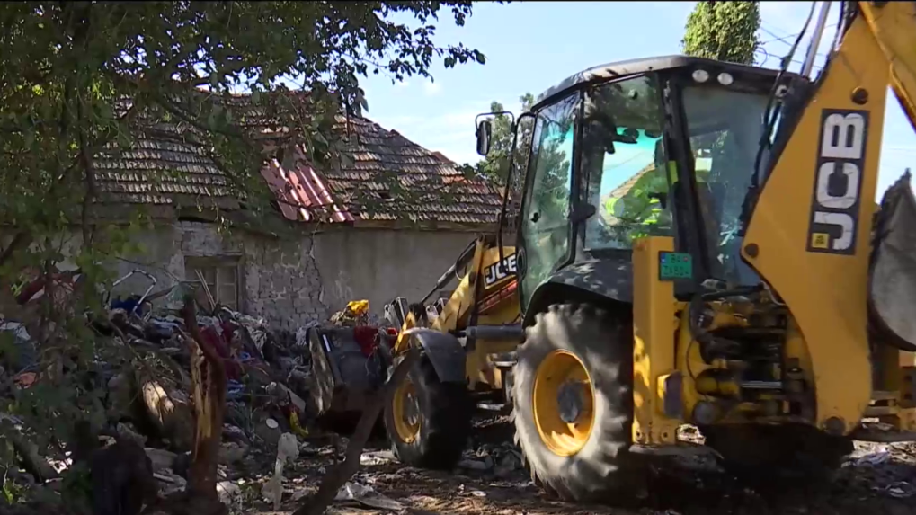 Bager naberá odpad pri starom rodinnom dome v Hurbanove.