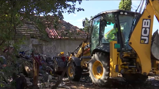 Bager naberá odpad pri starom rodinnom dome v Hurbanove.