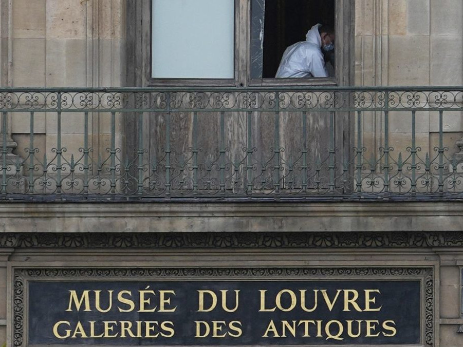 Kriminalista skúma miesto činu v Louvri.