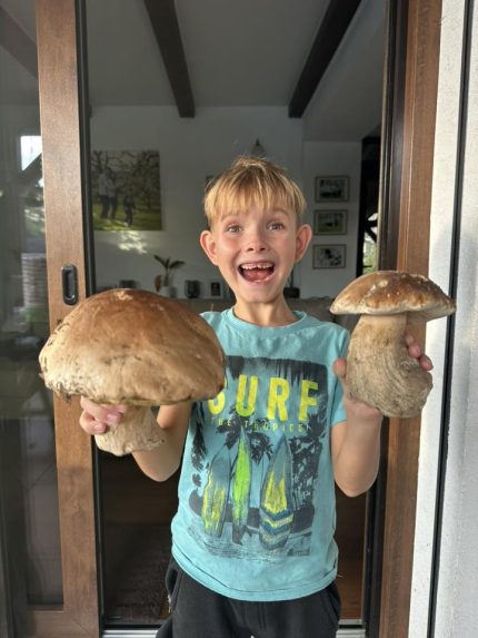 Na snímke chlapec drží v rukách veľké huby a raduje sa.