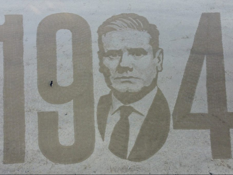 Na ilustračnej snímke Orwellow portrét vykopaný v piesku.