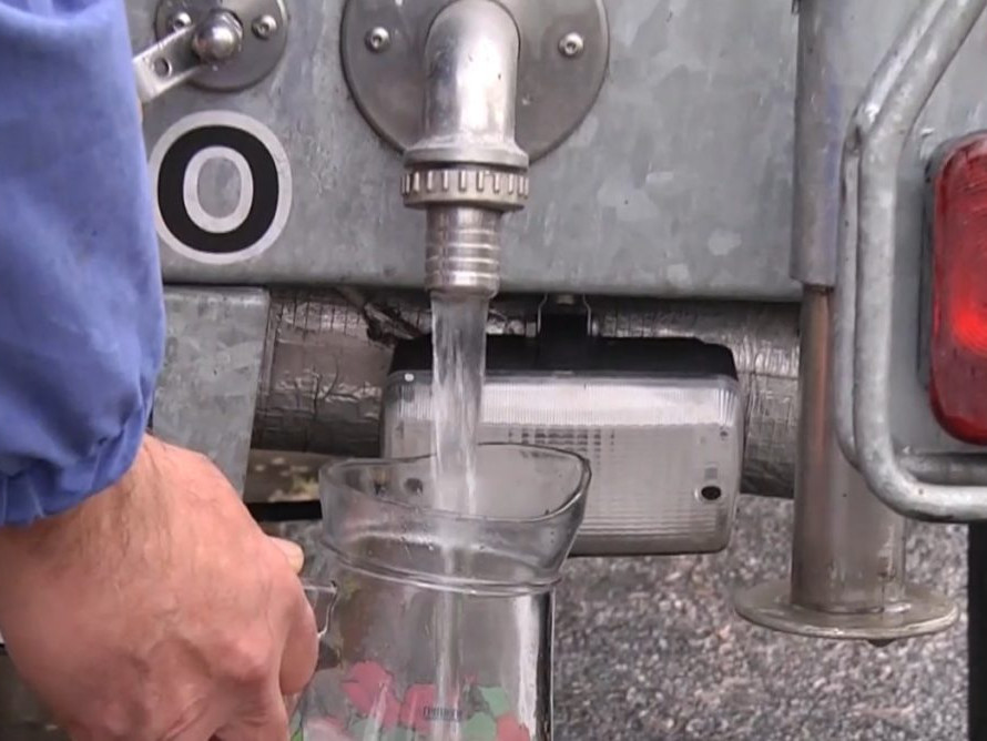 Na ilustračnej snímke muž naberá vodu z cisterny.