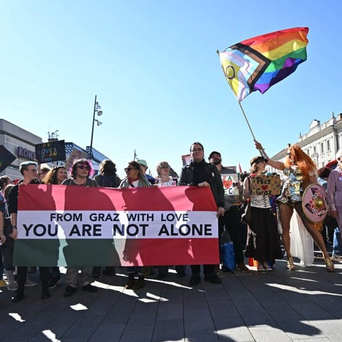 Ľudia s LGBT+ vlajkami na pochode Pride v Pécsi.
