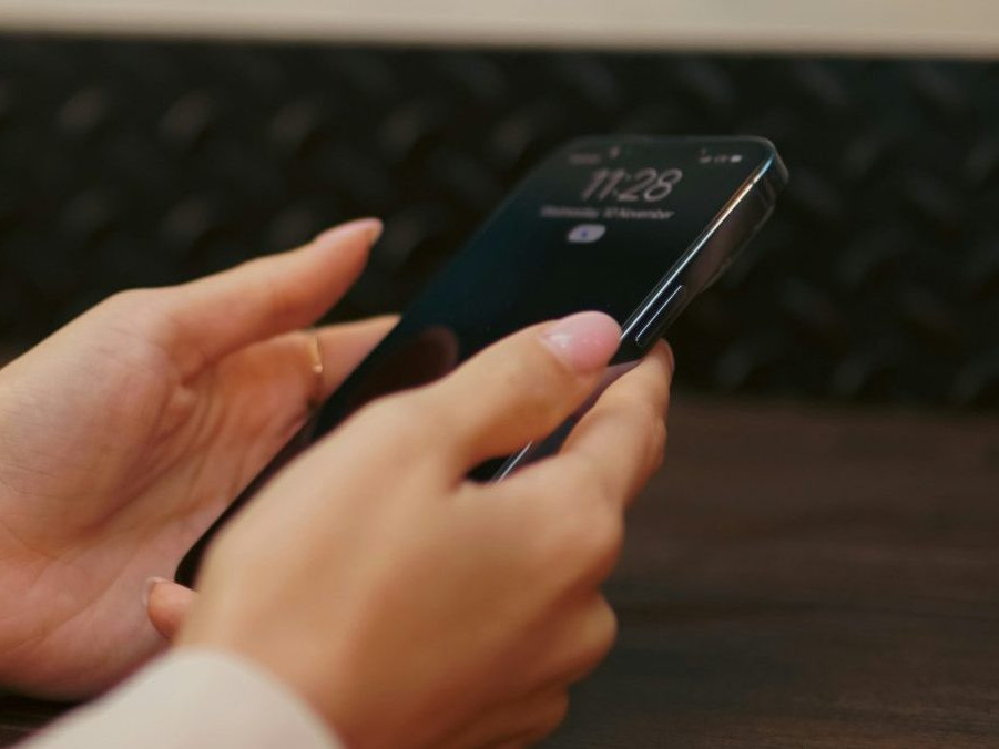 Na ilustračnej snímke osoba drží mobilný telefón.