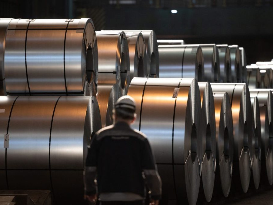 Zamestnanec oceliarne sa prechádza pred zvitkami ocele v nemeckom závode.