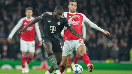 Hráč Bayernu Dayot Upamecano (vpredu) uniká s loptou pred Mikelom Merinom z Arsenalu.