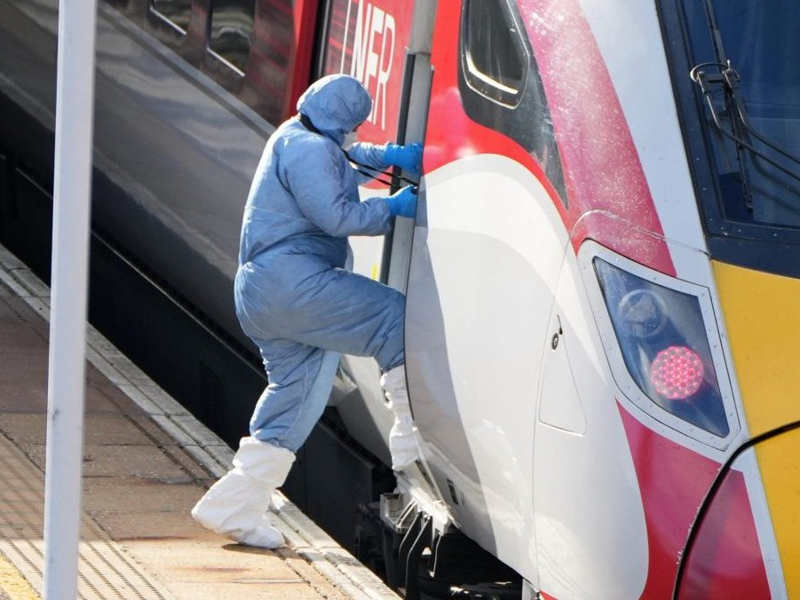 Forenzný vyšetrovateľ vstupuje do vlaku po útoku nožom.