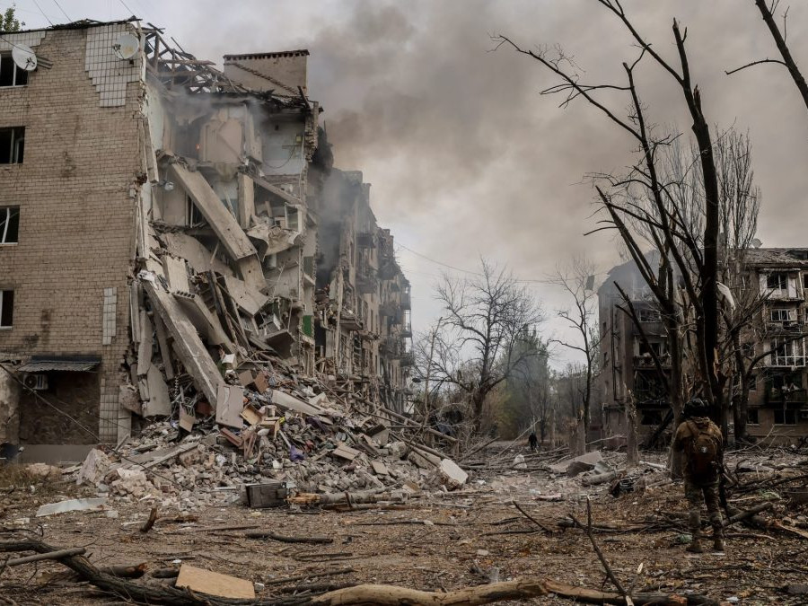 Muž pri zničených bytovkách v Doneckej oblasti.