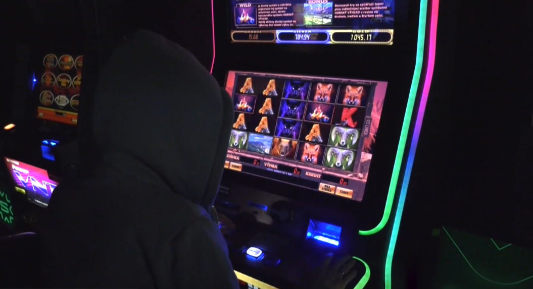 Na snímke človek sedí za automatom.