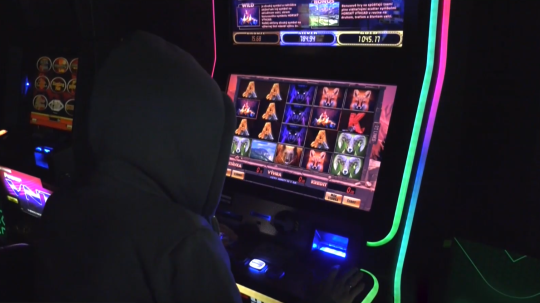 Na snímke človek sedí za automatom.