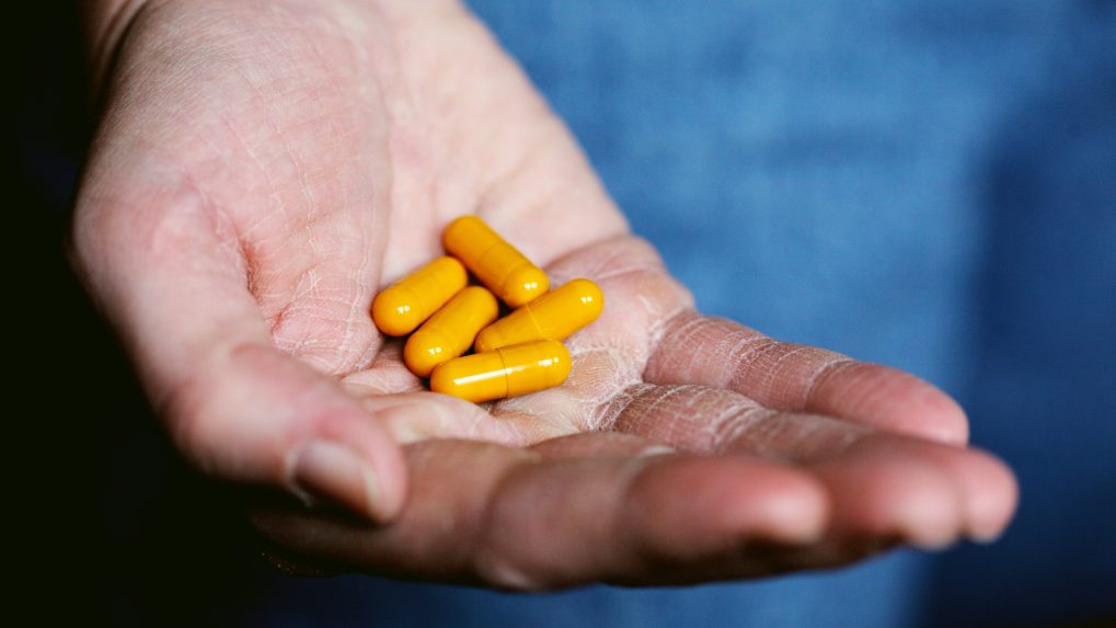 V ruke osoby sú lieky v mäkkých kapsulách.