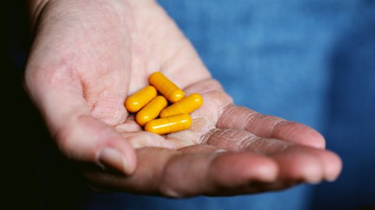 V ruke osoby sú lieky v mäkkých kapsulách.