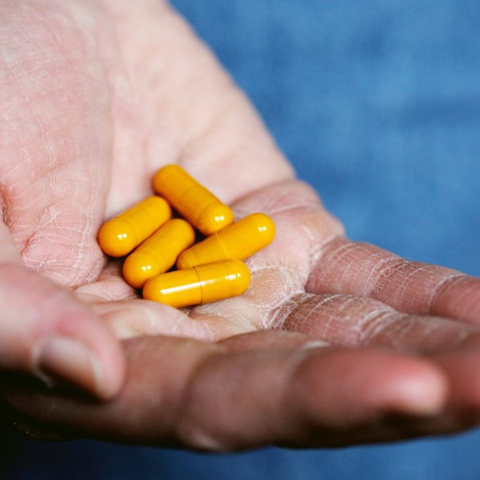 V ruke osoby sú lieky v mäkkých kapsulách.
