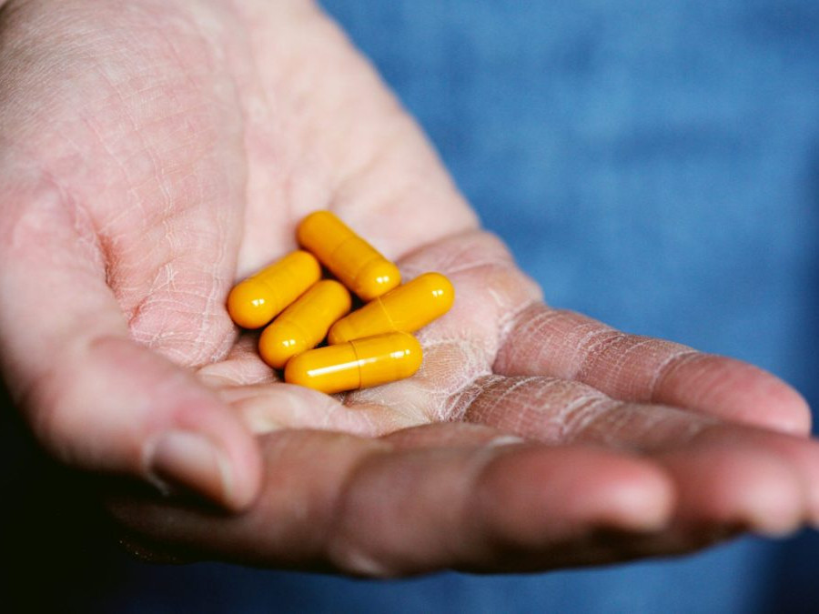 V ruke osoby sú lieky v mäkkých kapsulách.