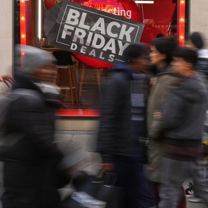 Na ilustračnej snímke ľudia v pohybe pred výkladom s Black Friday.