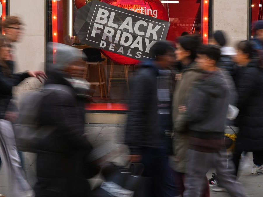 Na ilustračnej snímke ľudia v pohybe pred výkladom s Black Friday.