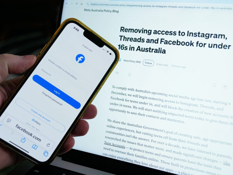 Na snímke prihlasovacia obrazovka na facebook na obrazovke telefónu pred monitorom.