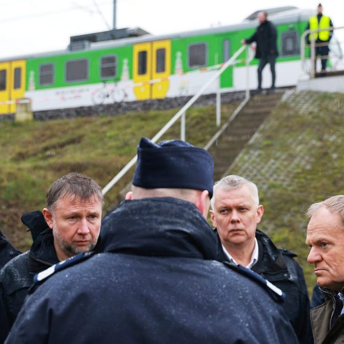 Na snímke Donald Tusk a polícia pri železnici.