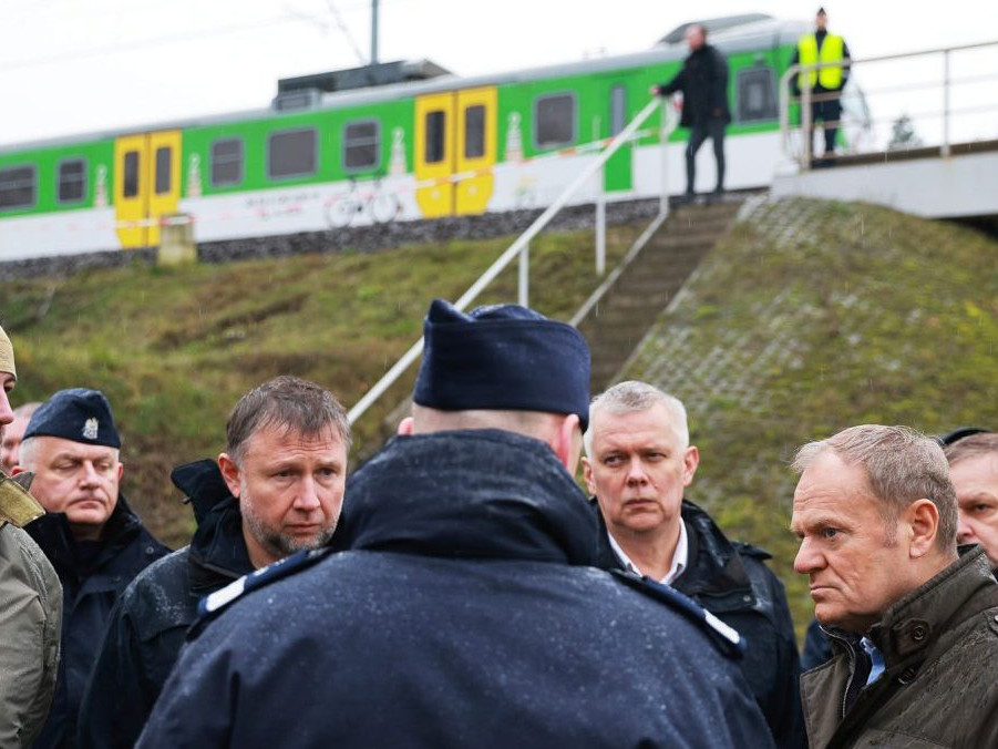 Na snímke Donald Tusk a polícia pri železnici.
