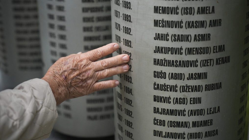 Ľudia pri pomníku na pamiatku detí zabitých počas obliehania Sarajeva v 90. rokoch.