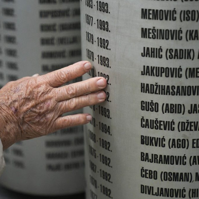 Ľudia pri pomníku na pamiatku detí zabitých počas obliehania Sarajeva v 90. rokoch.