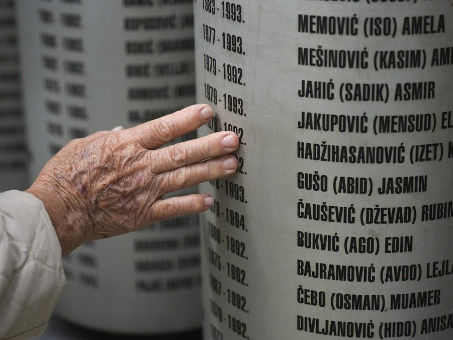 Ľudia pri pomníku na pamiatku detí zabitých počas obliehania Sarajeva v 90. rokoch.