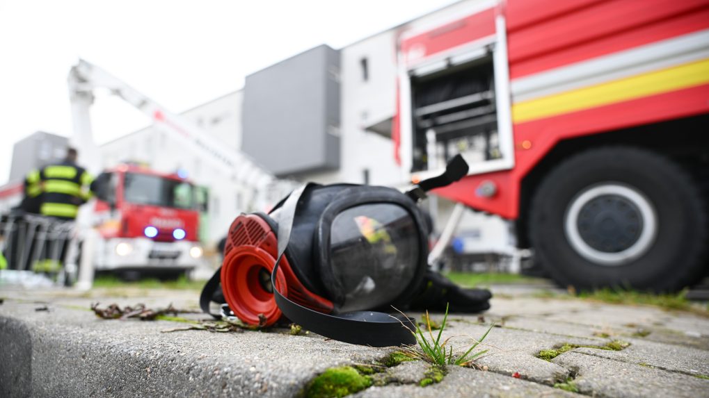 Na snímke hasičská maska pred bytovým domom, v ktorom vypukol požiar v Senici.