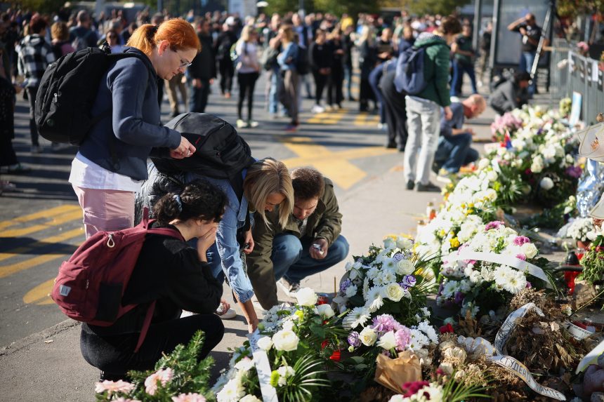 ľudia kladú kvety na pamiatku obetí vlakového nešťastia