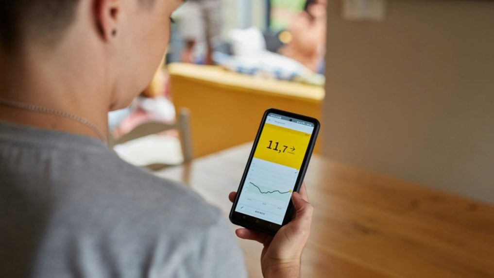 Žena s cukrovkou sleduje výsledky merania hladiny cukru v krvi v mobilnej aplikácii.