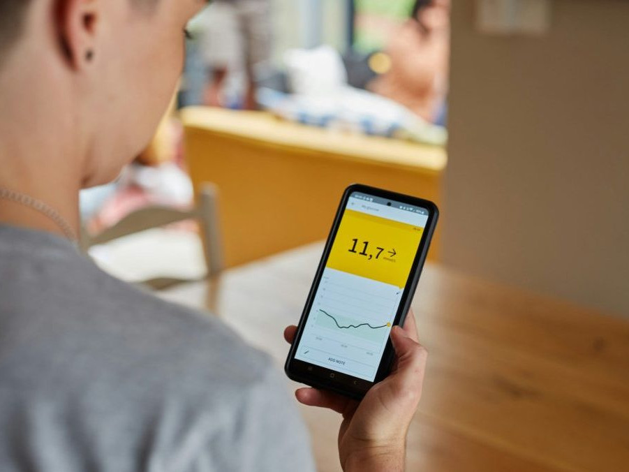 Žena s cukrovkou sleduje výsledky merania hladiny cukru v krvi v mobilnej aplikácii.