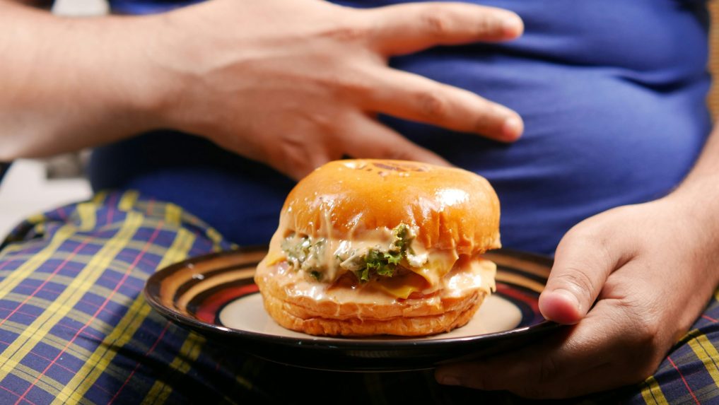 obézny človek a burger