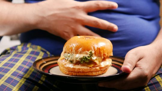 obézny človek a burger