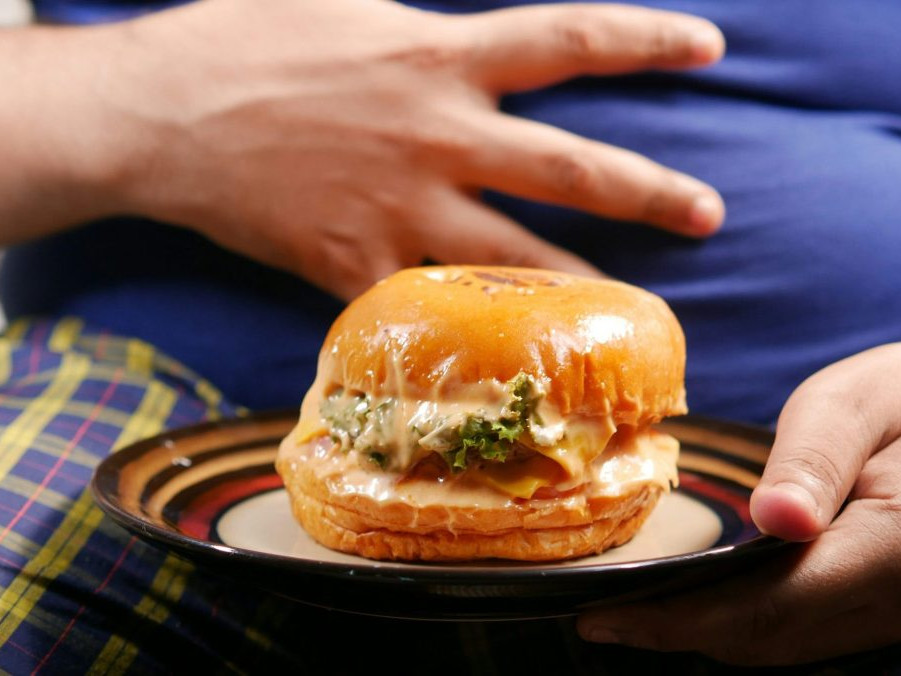 obézny človek a burger