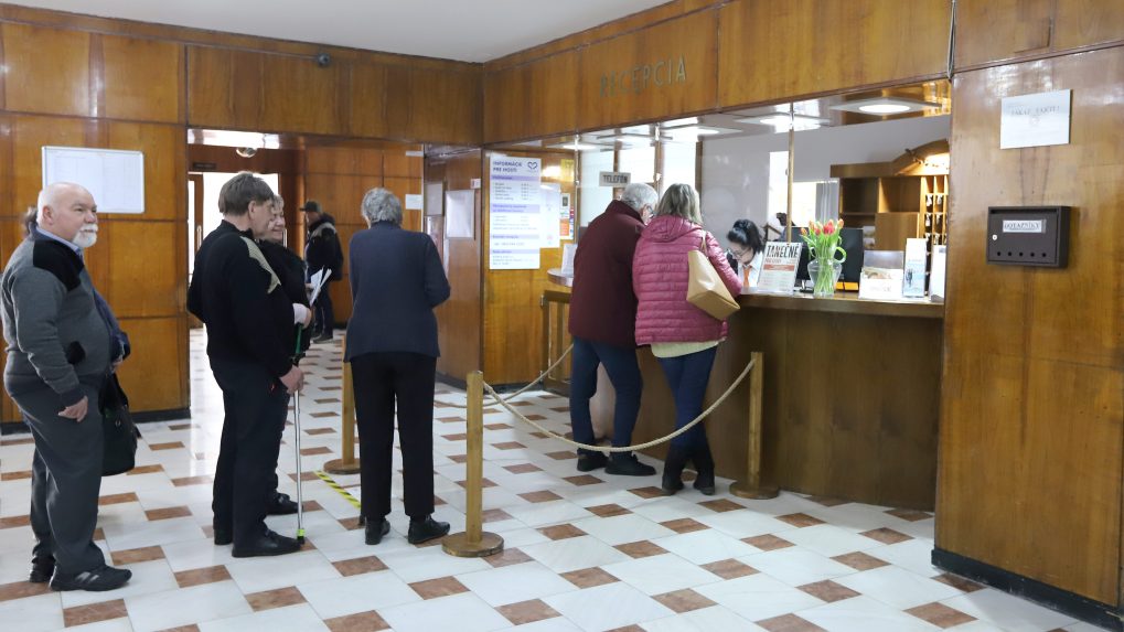Ľudia čakajú v rade na recepcii v kúpeľoch Sliač.