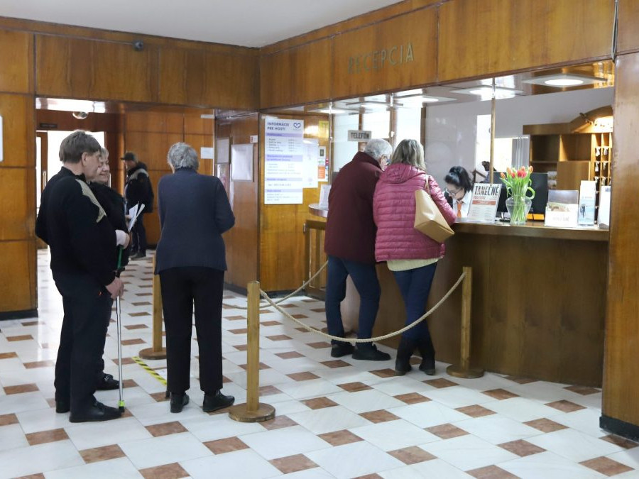 Ľudia čakajú v rade na recepcii v kúpeľoch Sliač.