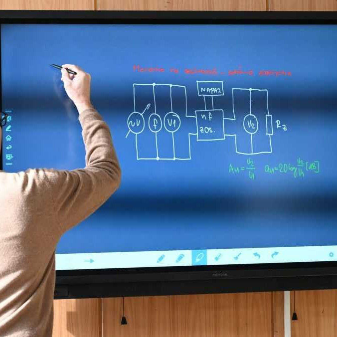 Na ilustračnej snímke pedagóg pri digitálnej tabuli.