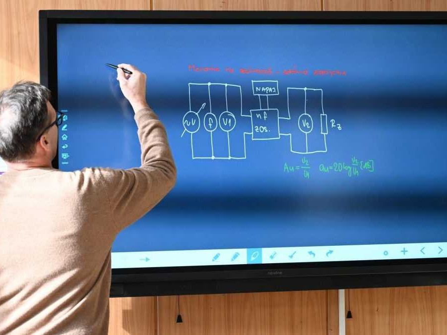 Na ilustračnej snímke pedagóg pri digitálnej tabuli.