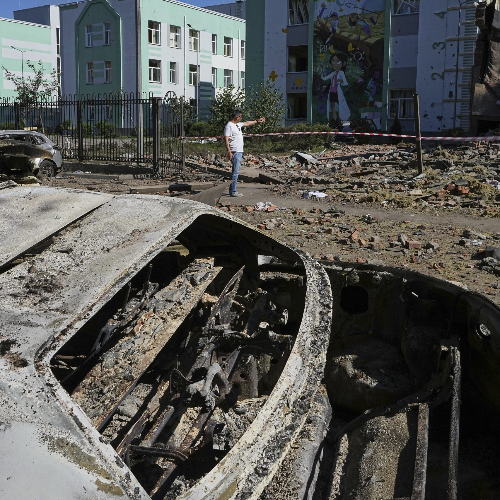 Na snímke v popredí je ruským útokom zničené auto, v okolí sú trosky.