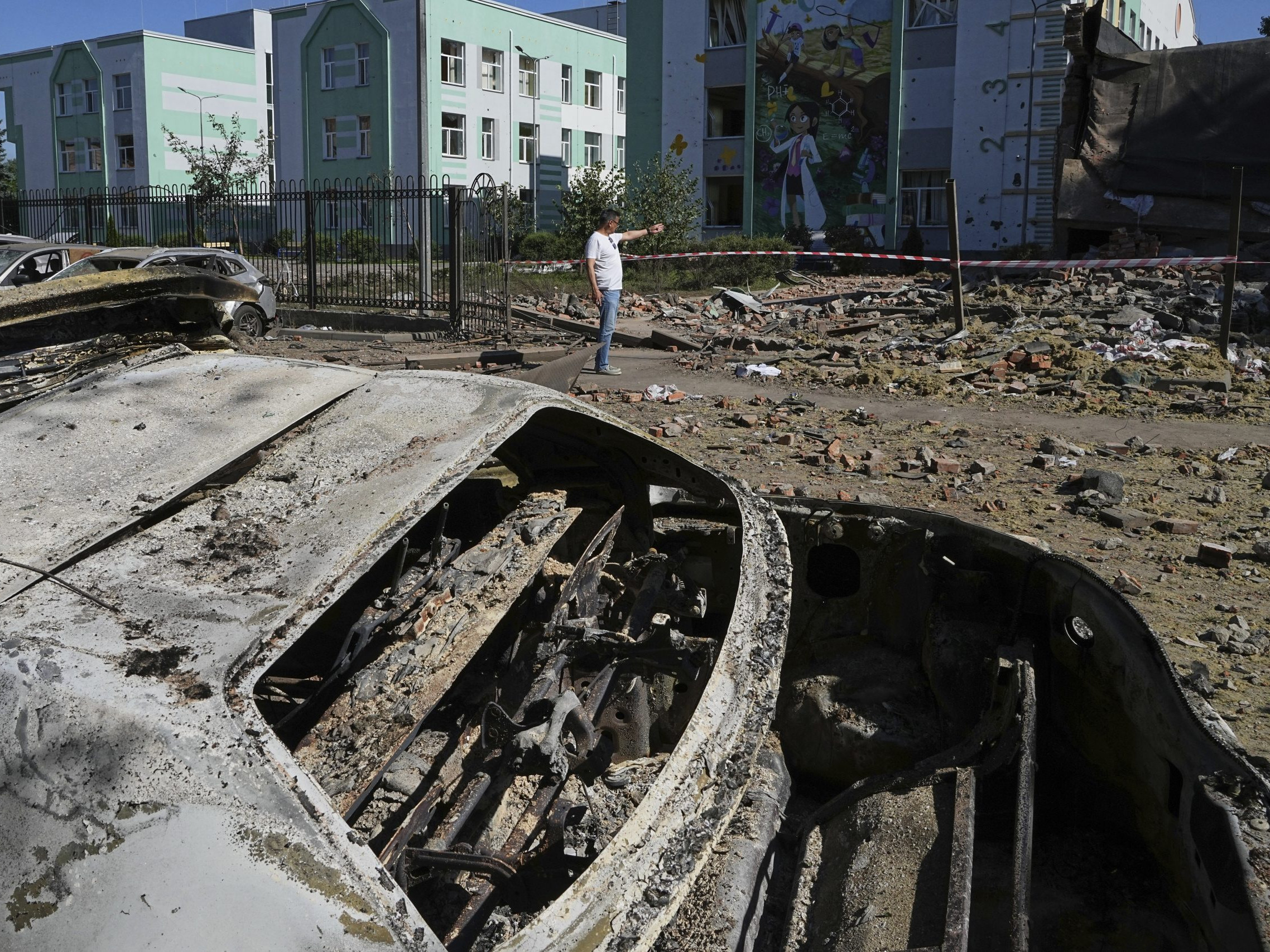 Na snímke v popredí je ruským útokom zničené auto, v okolí sú trosky.