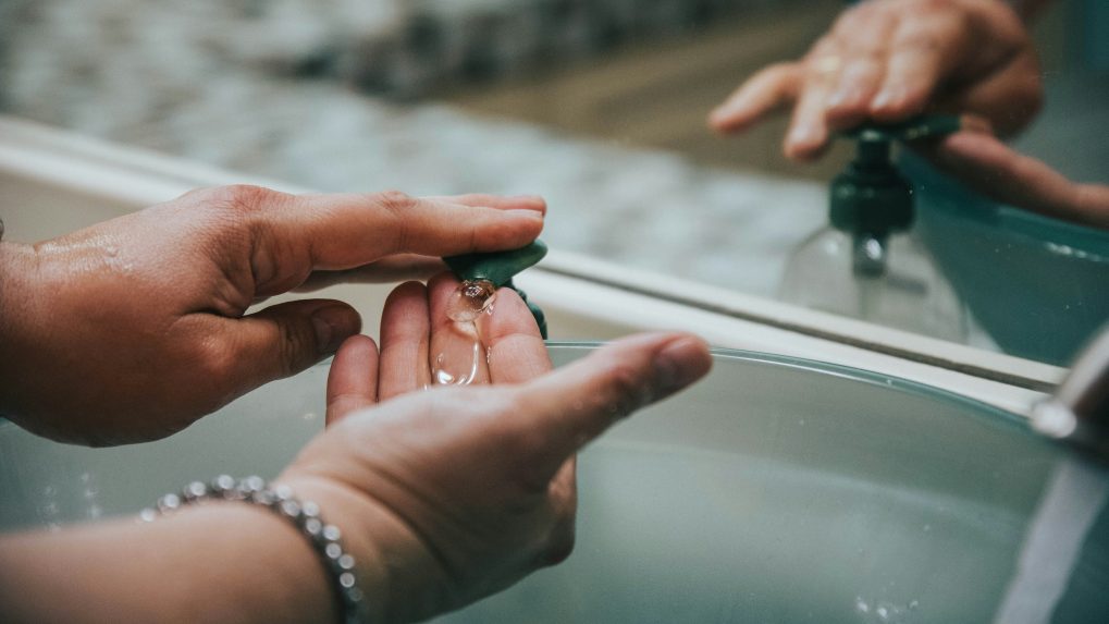 Na snímke si osoba umýva ruky v umývadle tekutým mydlom.